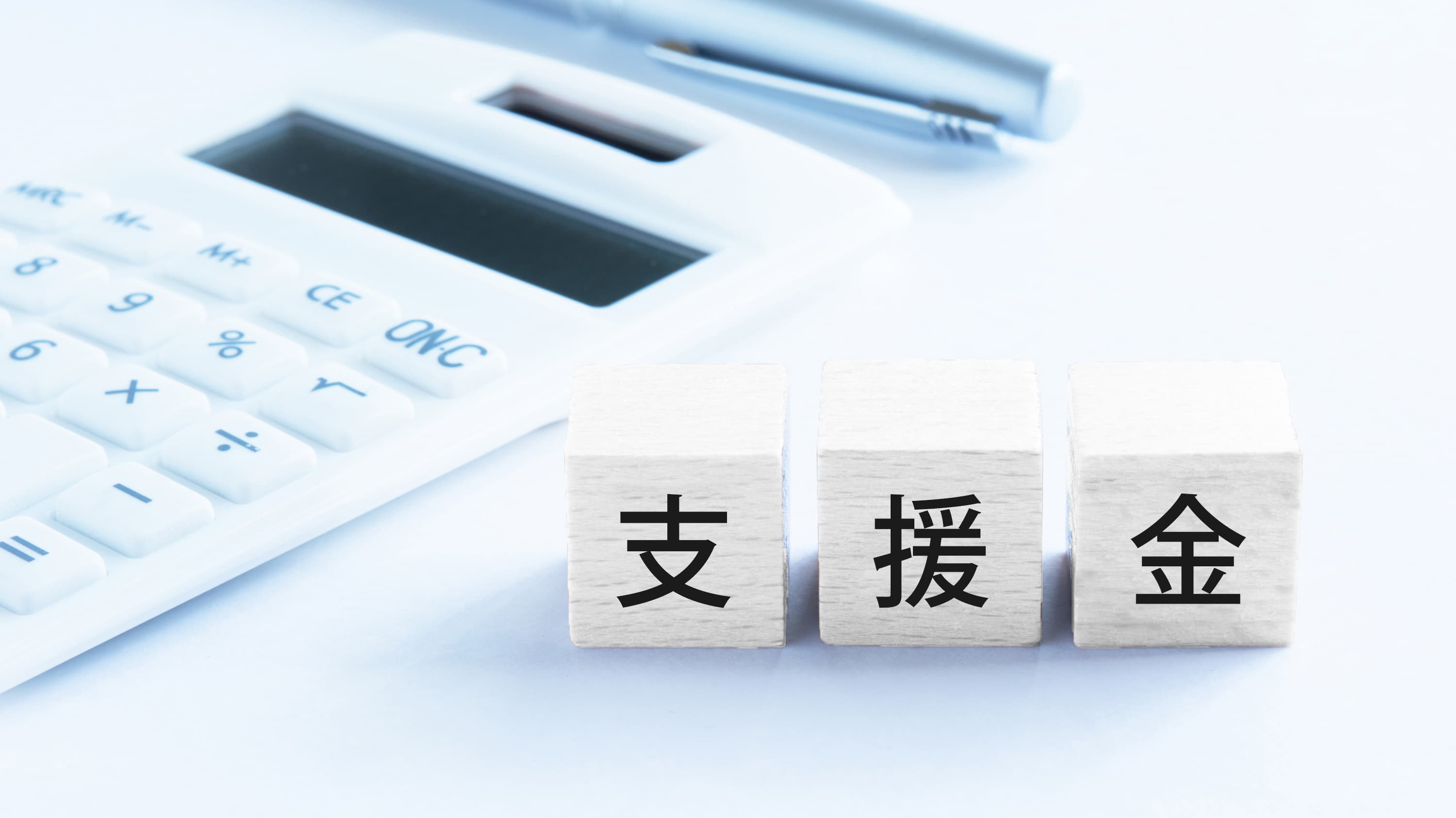 電卓を背景に支援金を表す画像